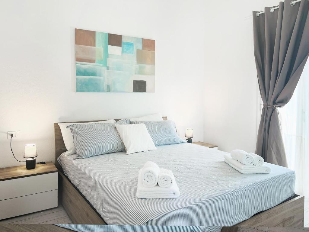 a bedroom with a bed with two towels on it at Case Vacanza il Sole in La Maddalena