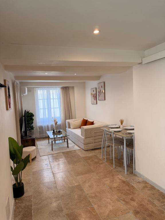 a living room with a couch and a table at Le petit nid provençal in Sorgues