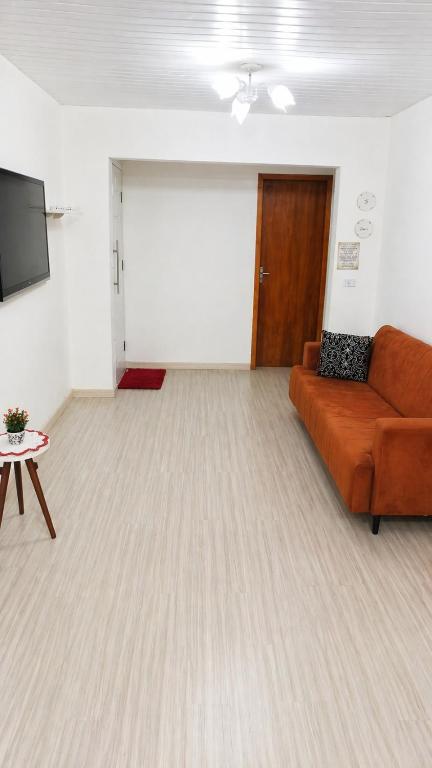 a living room with a couch and a flat screen tv at Casa J&G in Fazenda Rio Grande