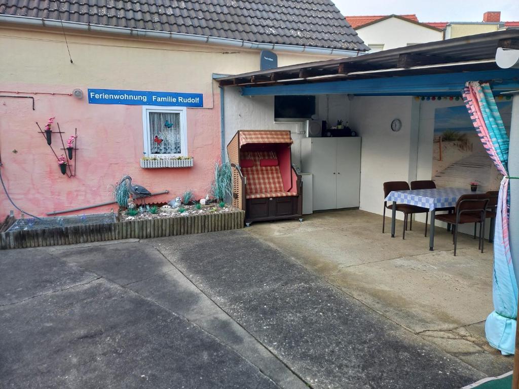 a pink house with a table and chairs on a patio at Ferienwohnung Familie Rudolf in Coswig