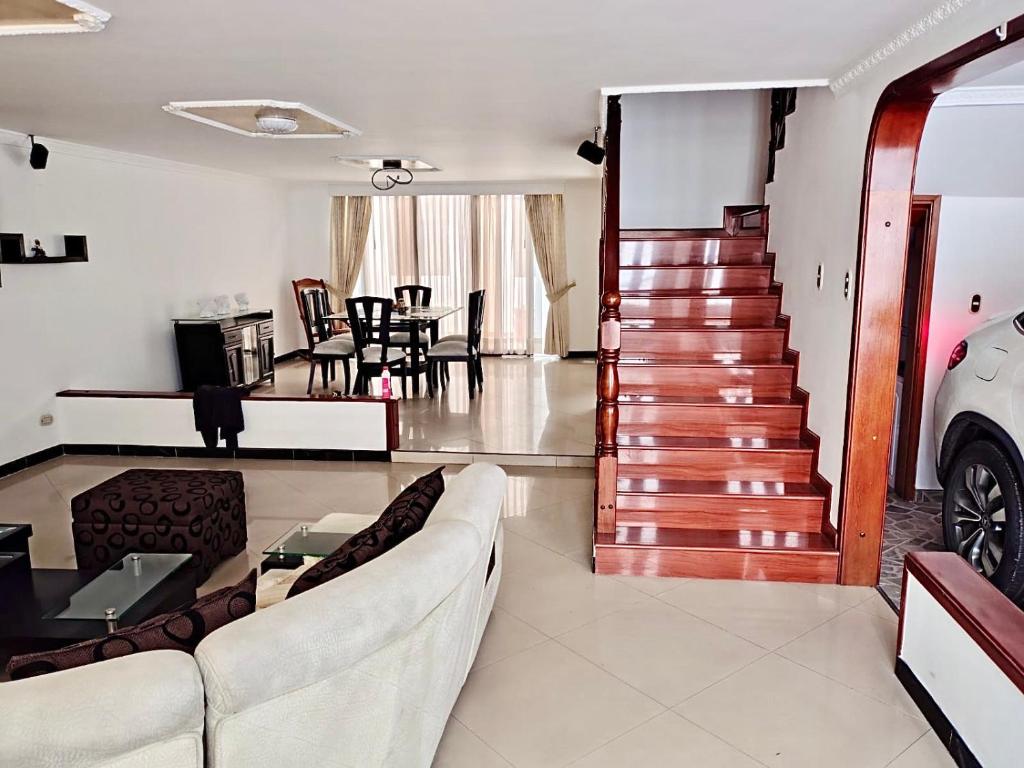 a living room with a couch and a staircase at Casa cerca al Campín in Bogotá