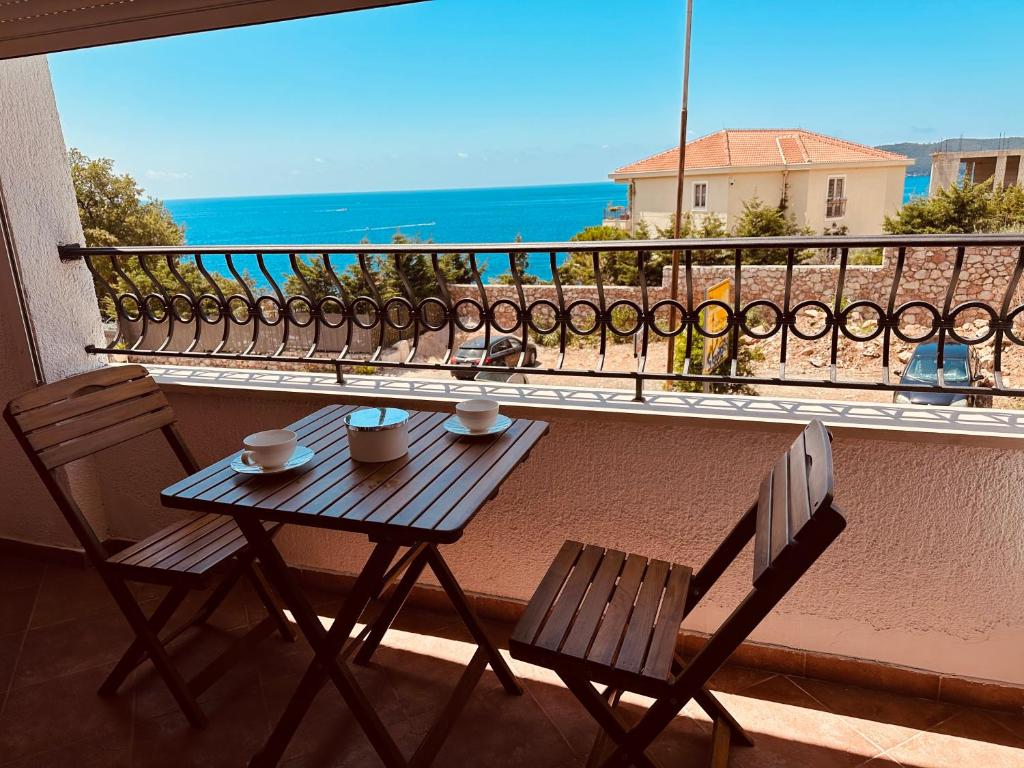 a table and chairs on a balcony with a view of the ocean at Serenity Seaview Suite Przno in Pržno