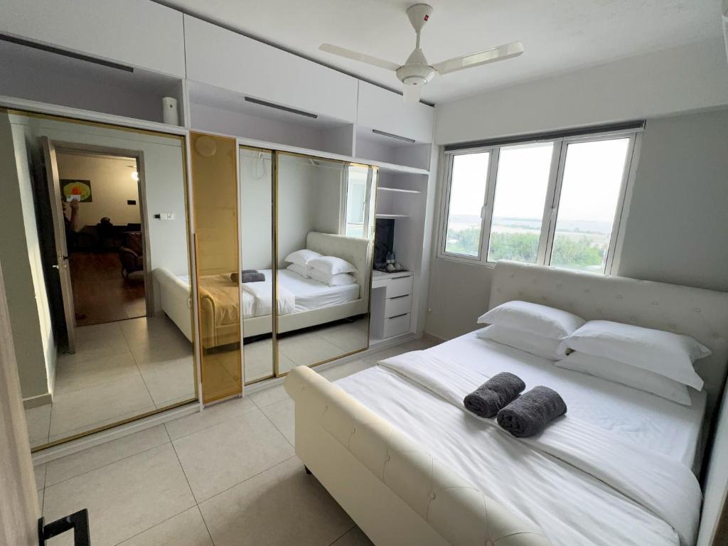 a bedroom with a large white bed and a mirror at Araam Retreat Deluxe in Male City