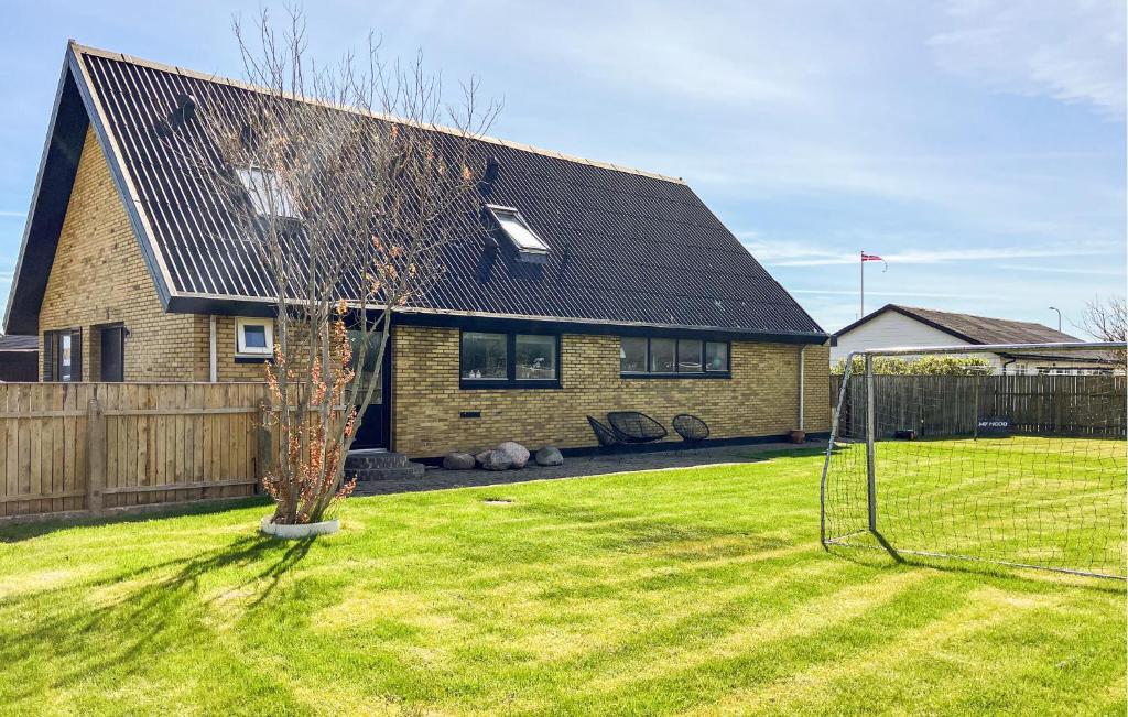 a house with a net in a yard at Awesome Home In Thyborøn With Wifi in Thyborøn