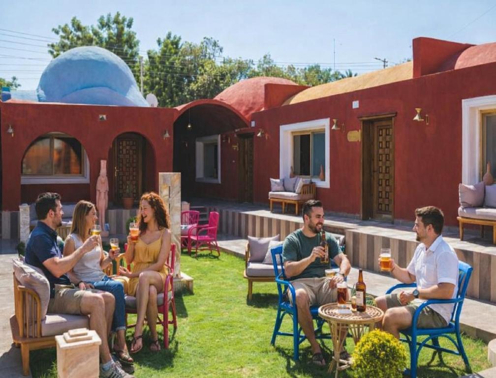 a group of people sitting on a patio outside a house at Tuya Abu Simbel Hotel in Abu Simbel