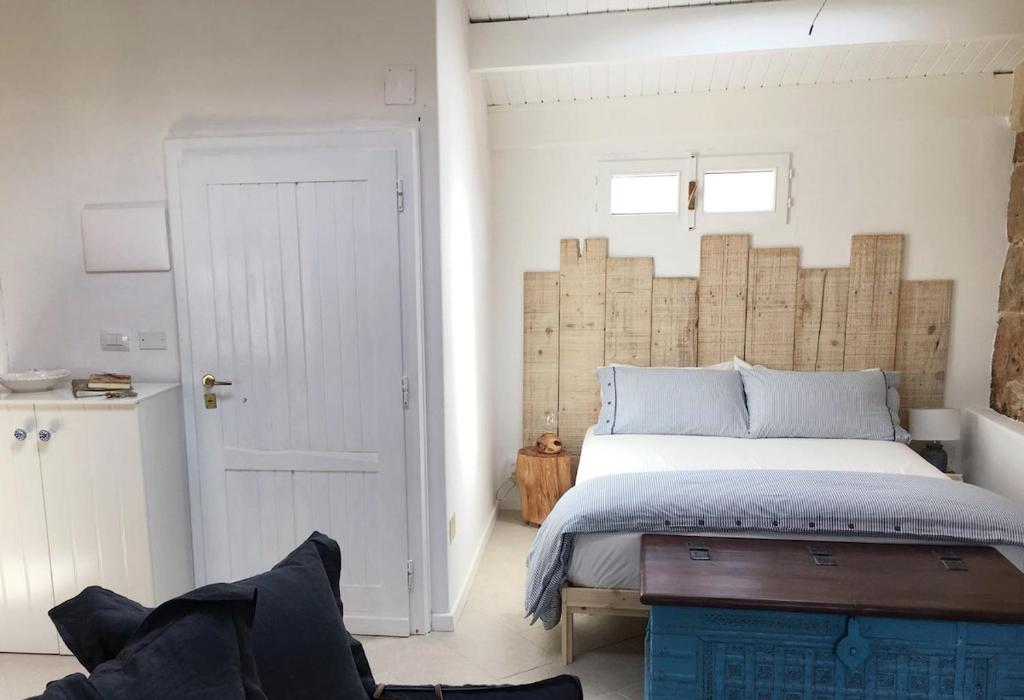 a bedroom with a bed with a wooden headboard at The three bell towers apartment in Alghero