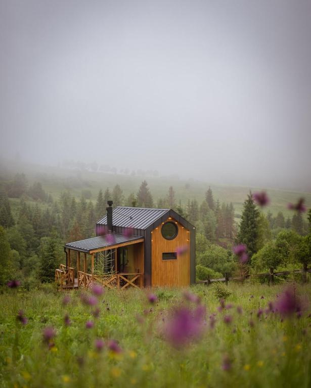 a small wooden house in a field of flowers at Silence cabin in Myta