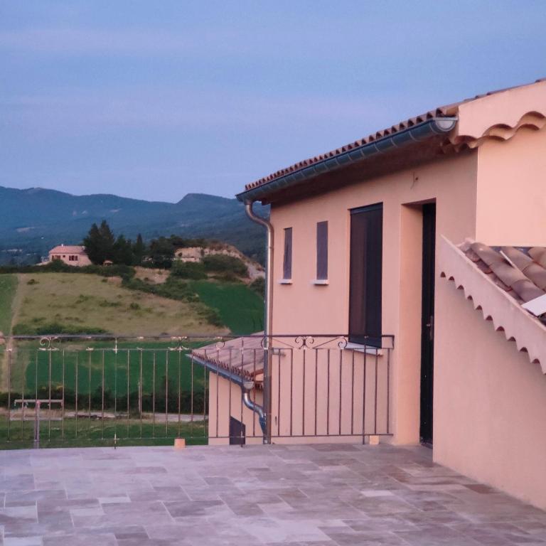 a house with a gate and a view of a hill at Gite Aubanel' Drôme Provencale in Saint-Auban-sur-Ouvèze