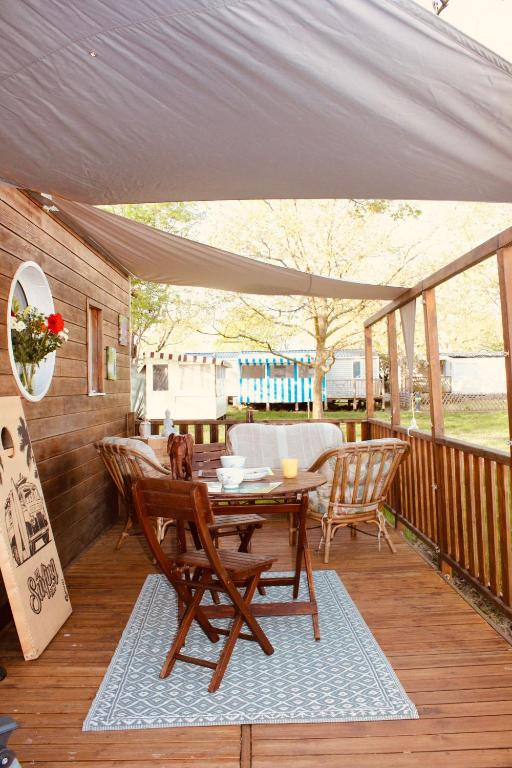 a patio with a table and chairs on a deck at Tiny House cosy 4 personnes in Vaux-sur-Mer