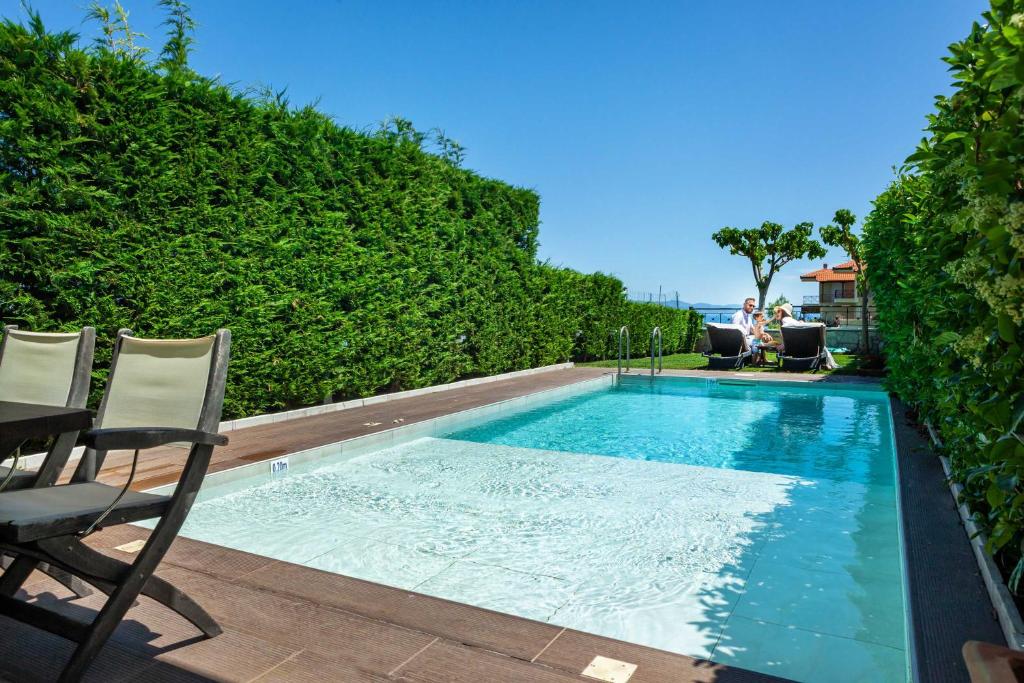 a swimming pool with two chairs and a table at Sunny Exclusive Tria in Hanioti
