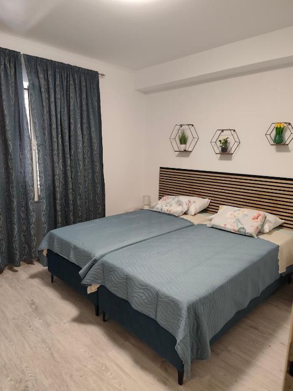 a bedroom with a large bed with blue sheets at Guest House Oscar near the Sea and river in Mokošica