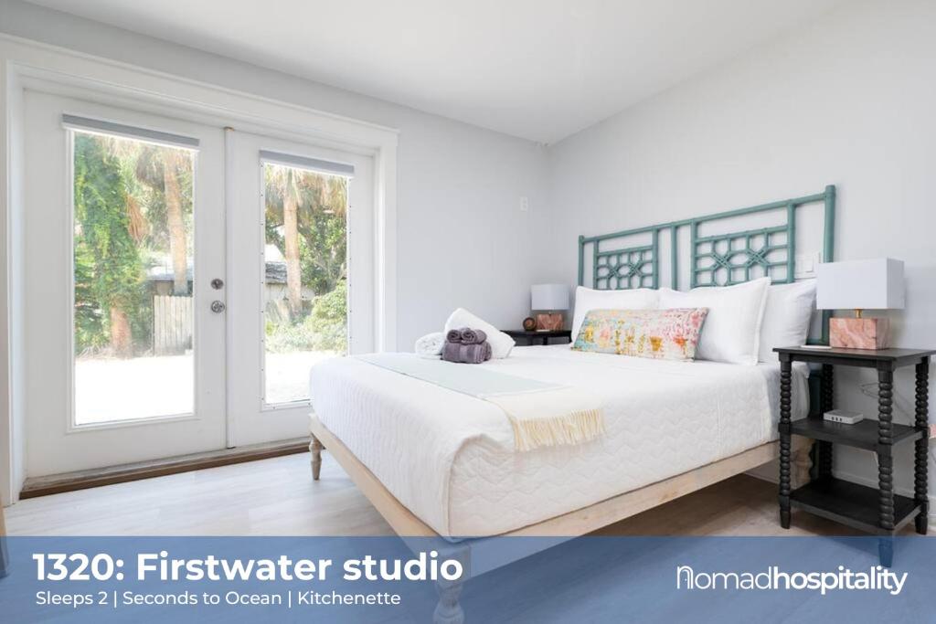 a white bedroom with a bed and a window at Be A Nomad - Jacksonville Beach Studio - 60-Second Walk to Ocean - Sleeps 2 in Jacksonville Beach
