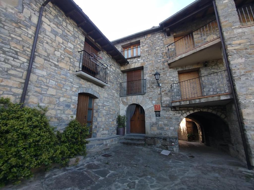 an old stone building with wooden doors and balconies at Casa Cosculluela in Aínsa
