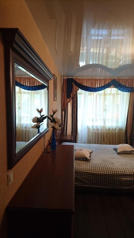 エイスクにあるApartment on Plekhanovaのベッドルーム1室(ベッド1台付)、窓(カーテン付)