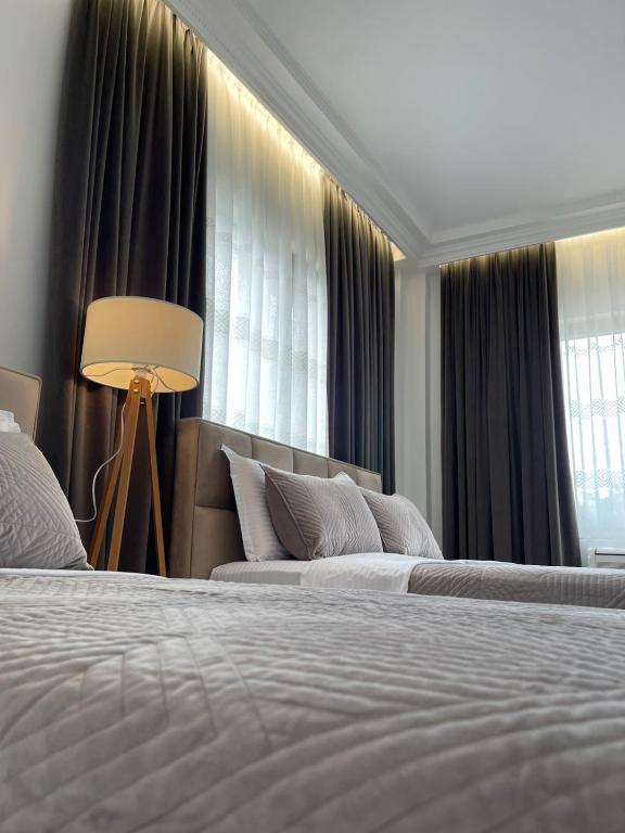 a hotel room with two beds and a window at Guest House Nuhellari 2 in Çorovodë