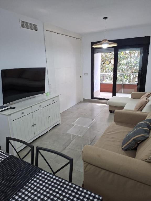 a living room with a couch and a flat screen tv at La casa en la playa in Rota