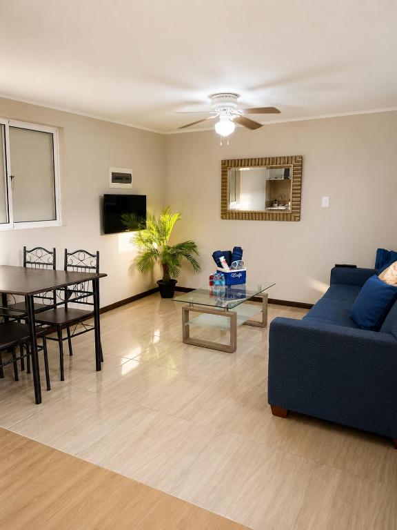 a living room with a blue couch and a table at Valfe Apartments in Palm-Eagle Beach