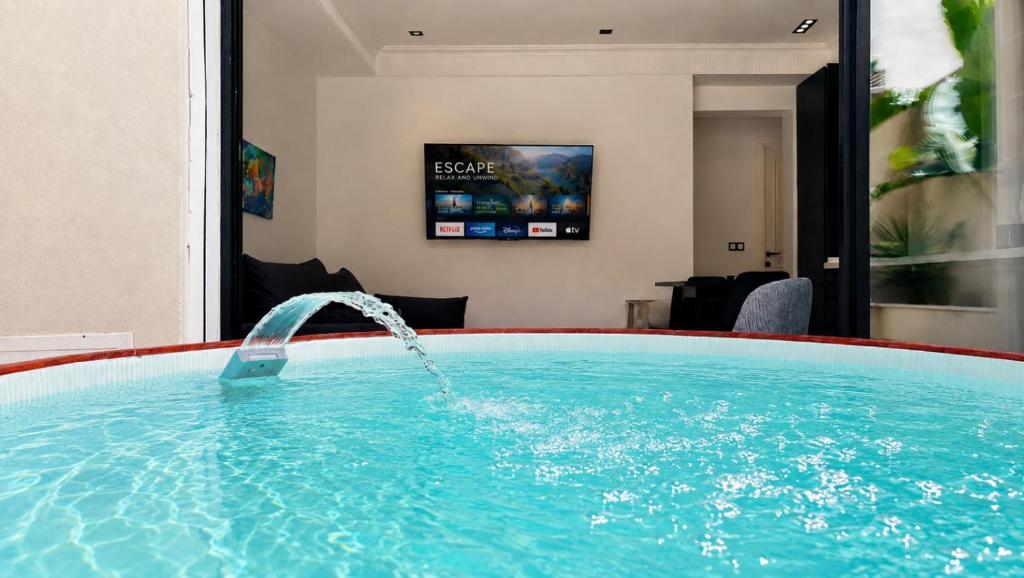 a pool with a water fountain in a hotel room at Prestige House La Marsa Terrasse Jacuzzi & Garage in La Marsa