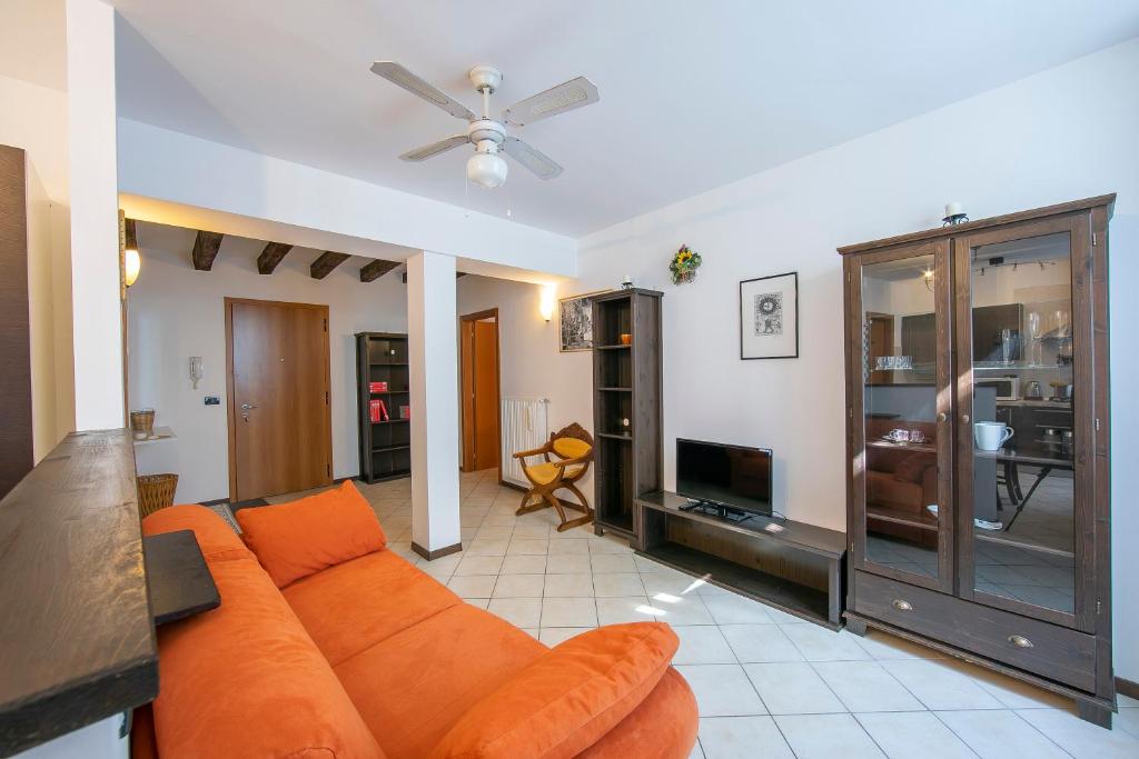 a living room with an orange couch and a tv at Casa Azzurra 150m From Lake Garda - Happy Rentals in Riva del Garda