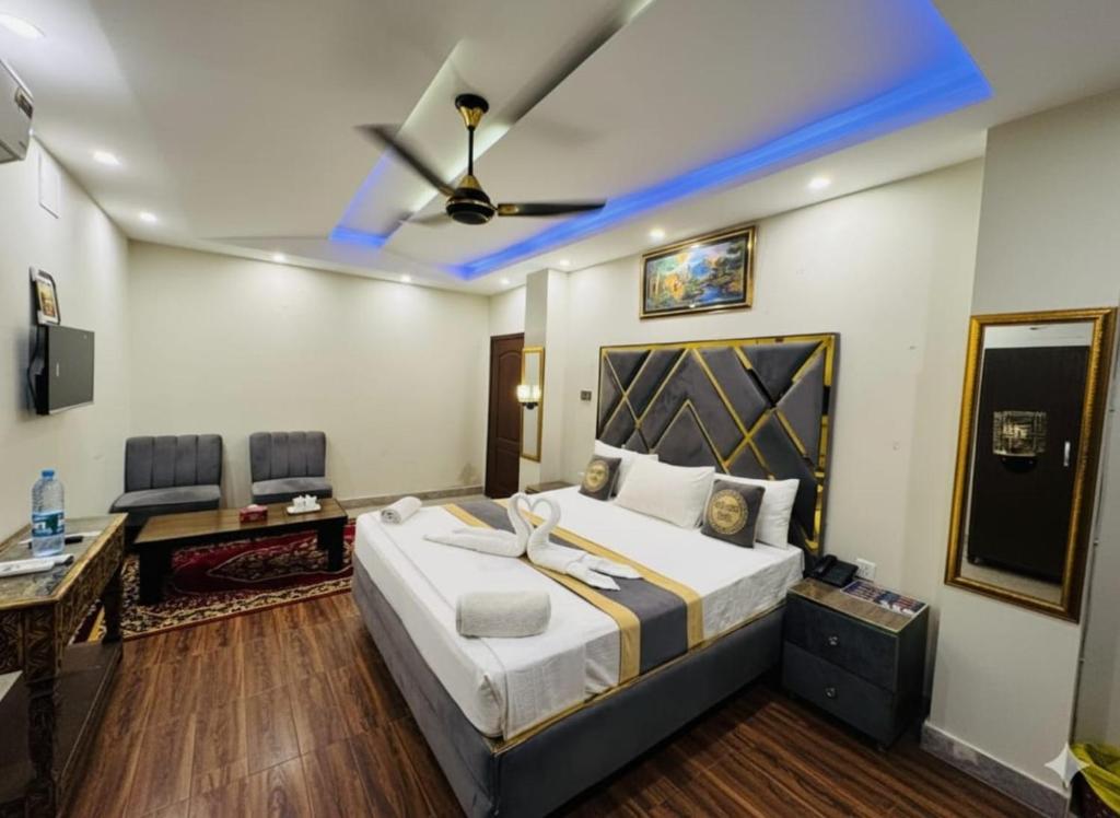 a bedroom with a large bed with a ceiling fan at Hotel Swiss Pearl in Lahore