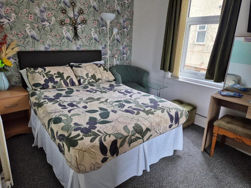 a bedroom with a bed with a floral wallpaper at Glendor Hotel in Blackpool