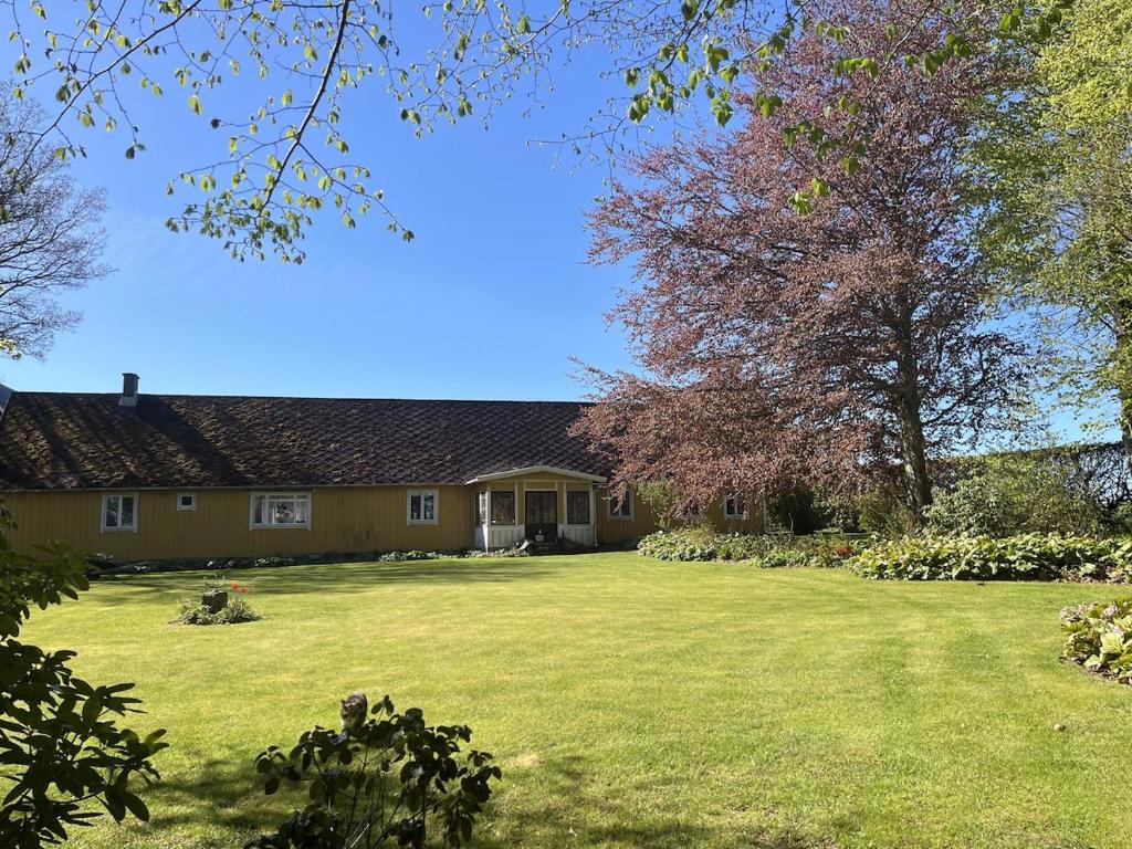 a house with a large yard with a large lawn at Starby bondgård in Ängelholm