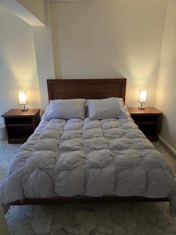 a bedroom with a bed with two lamps on two tables at Cumbre Guesthouse in Monterrey