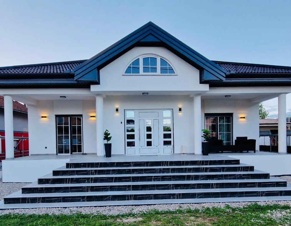 a white house with stairs in front of it at Villa Breza in Bihać