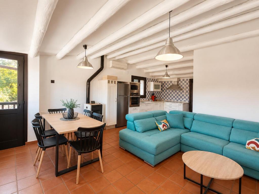 a living room with a blue couch and a table at Sésamo Apartamento in Hervás