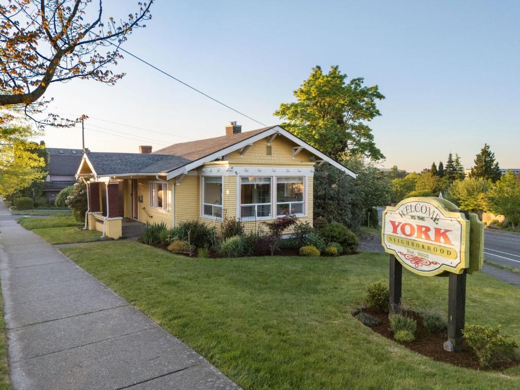 a yellow house with a sign in front of a yard at Yellow York House in Bellingham