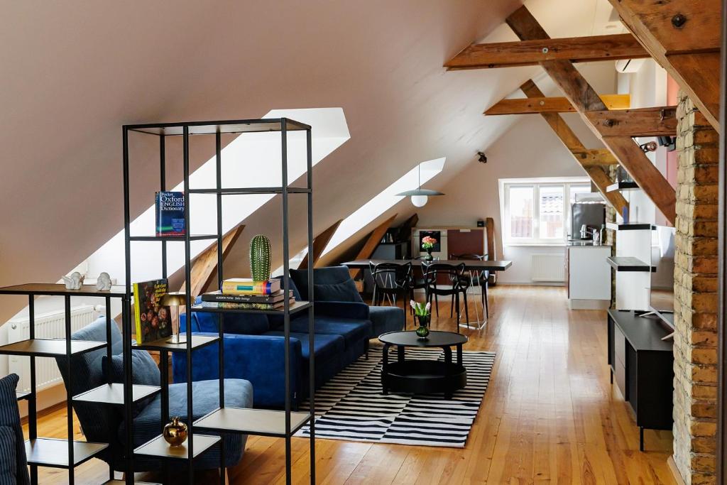 a living room with a blue couch and a table at Historic Haven in Riga