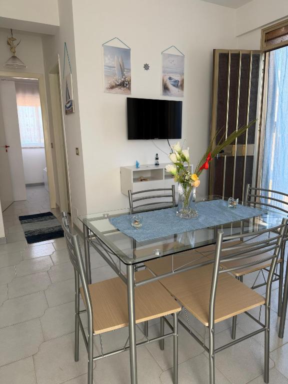 a dining room with a glass table and chairs at Nido sul Mare in Punta Braccetto