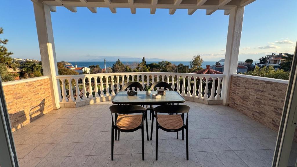 a table and chairs on a balcony with a view at Maison De La Mer in Paleo Tsifliki