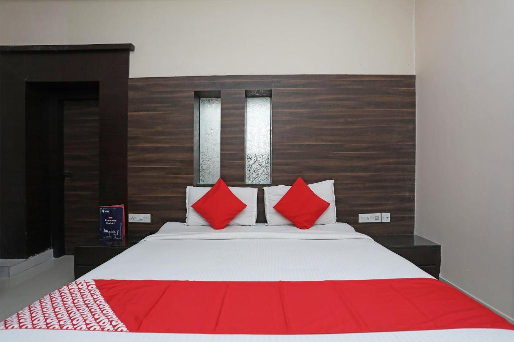 a bedroom with a large bed with red pillows at Hotel O South Fern in Kolkata