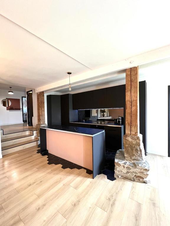 a large room with a kitchen and a fireplace at L'Héritage, Loft design et pierre in Dol-de-Bretagne