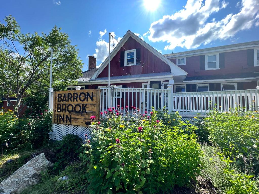 a house with a barn book inn sign in front of it at Barron Brook Inn in Whitefield