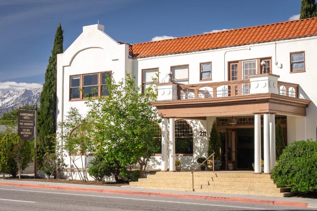 a white building with a balcony on a street at Winnedumah Hotel in Independence