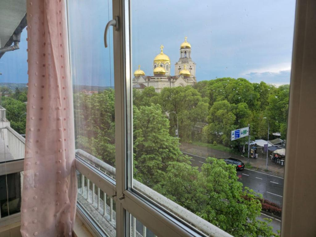 a window with a view of a building and a street at Grand and Prime Central Apartments Varna in Varna City