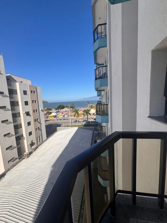 a balcony of a building with a view of the ocean at Flat a Beira Mar in Caraguatatuba