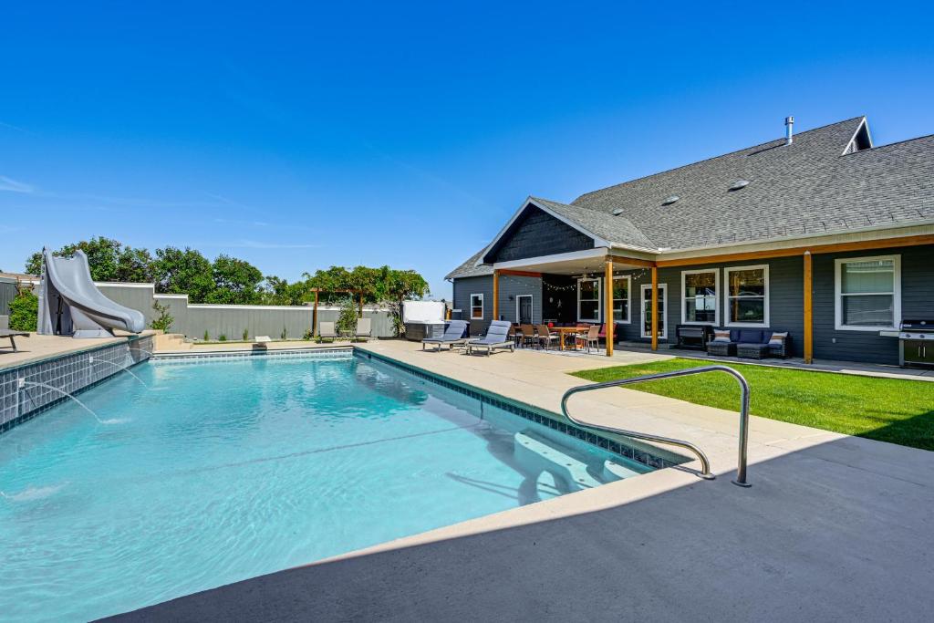 a swimming pool in front of a house at Hot Tub & Seasonal Pool: Remarkable Yakima Getaway in Yakima