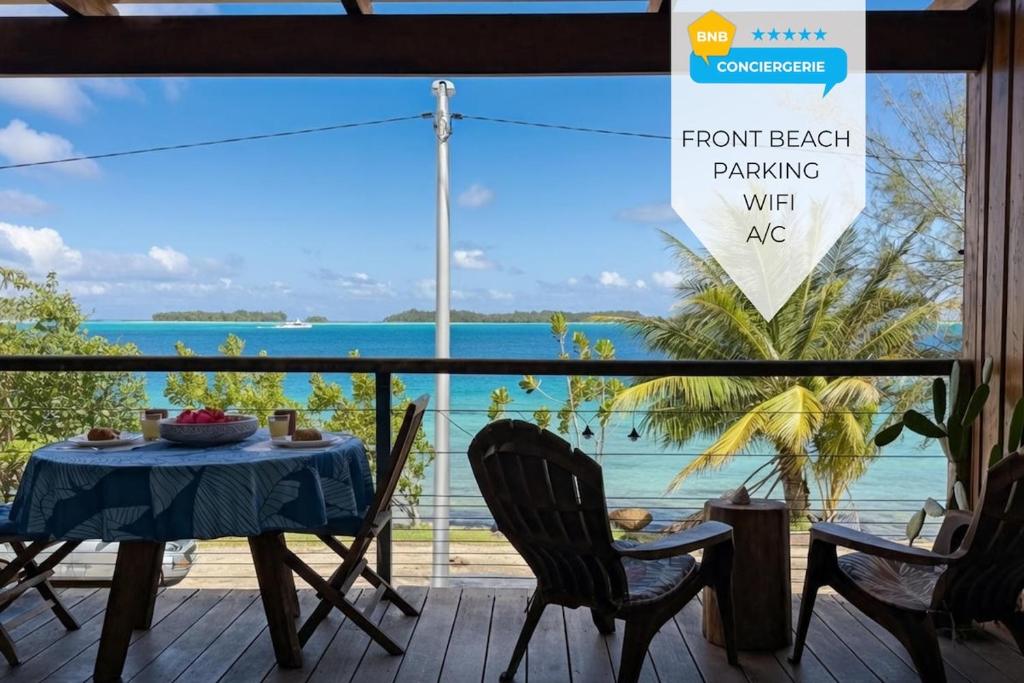 a table and chairs on a porch with a view of the ocean at Breathtaking Bora Bora Lagoon View Studio in Bora Bora