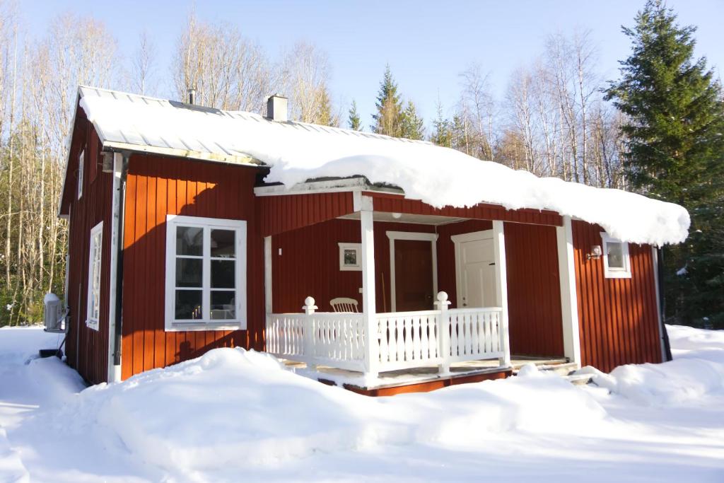 a red house with snow on the roof at Cozy forest cabin in Vik