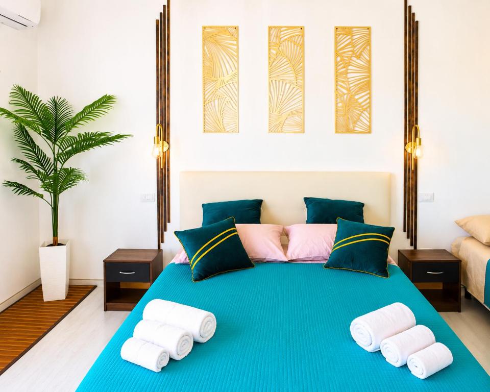 a bedroom with a blue bed with towels on it at Monolocale elegante con design moderno e atmosfera tropical chic in Nardò
