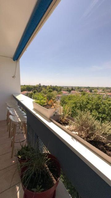 a balcony with chairs and potted plants on it at appartement mérignac avec parking in Mérignac