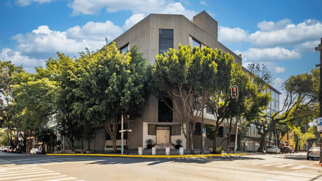 a building on the corner of a street at Uniko Living Roma in Mexico City