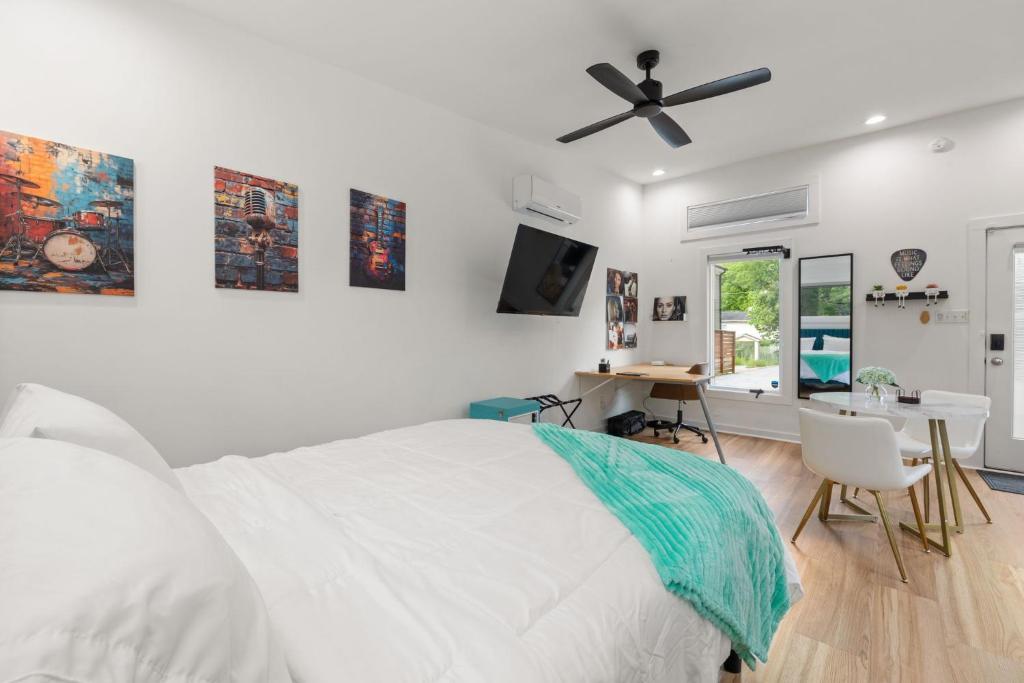 a bedroom with a bed and a desk and a ceiling fan at Irie Vibes Private Guest House Downtown in Raleigh