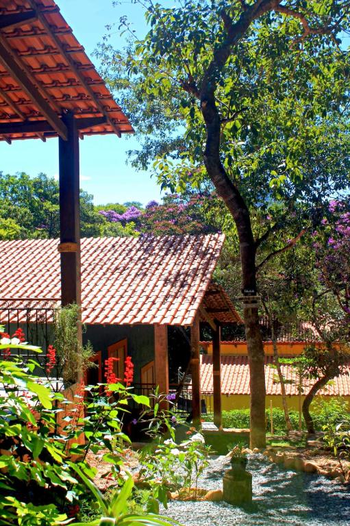 a garden with a pavilion and trees and flowers at Hospedaria Lunar in Palmeiras
