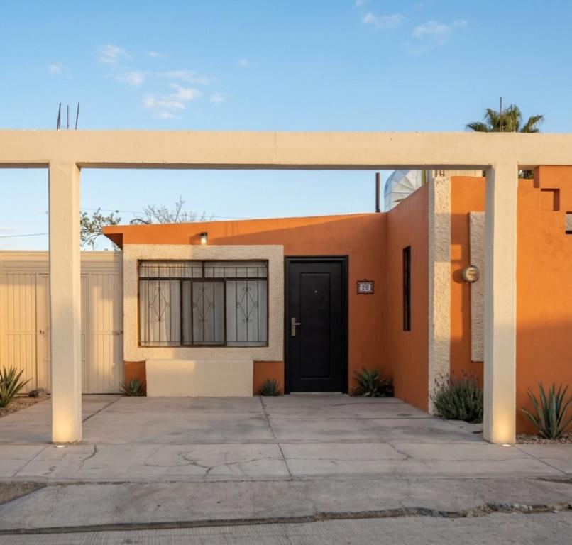 a orange house with a black door at Casa Rivota in Delicias