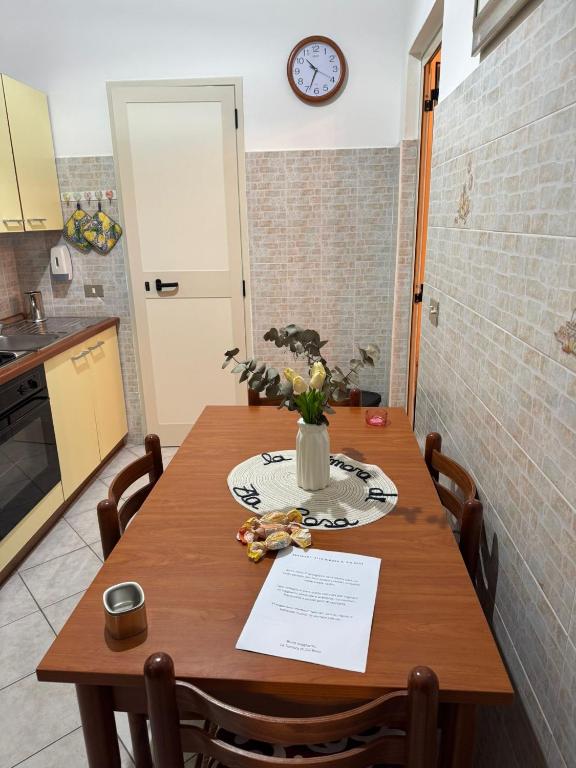 a kitchen with a wooden table with a vase of flowers at La Dimora di Zia Rosa in Crotone