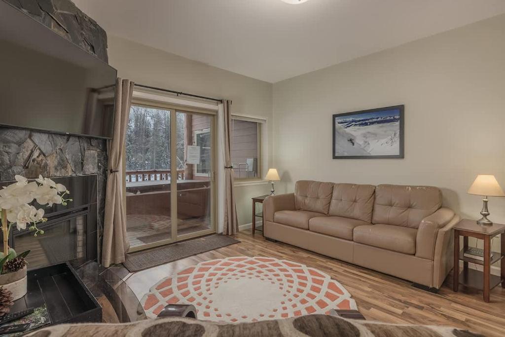 a living room with a couch and a fireplace at 2 Bedroom Mountain View Condo with Private Hottub in Girdwood